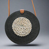 Black woven clutch with a floral pattern on a tiled floor